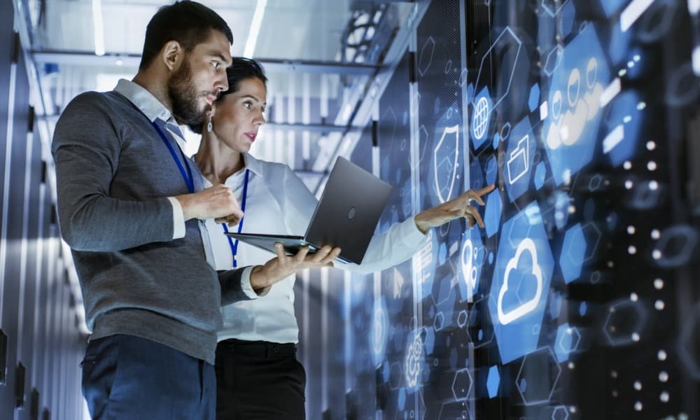 Two people look at a virtual presentation of I.T. infrastructure.