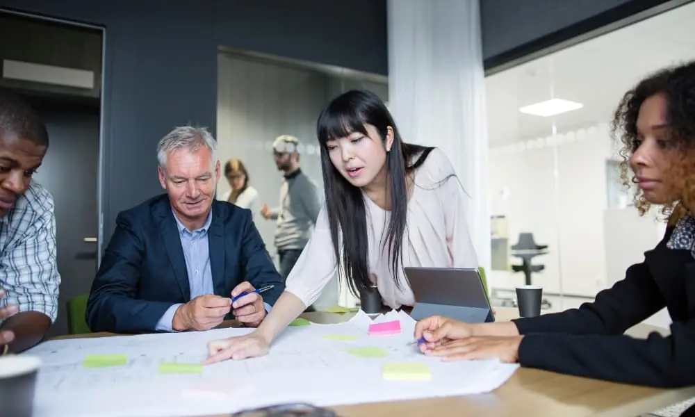 An I.T. professional consulting a team of business executives.