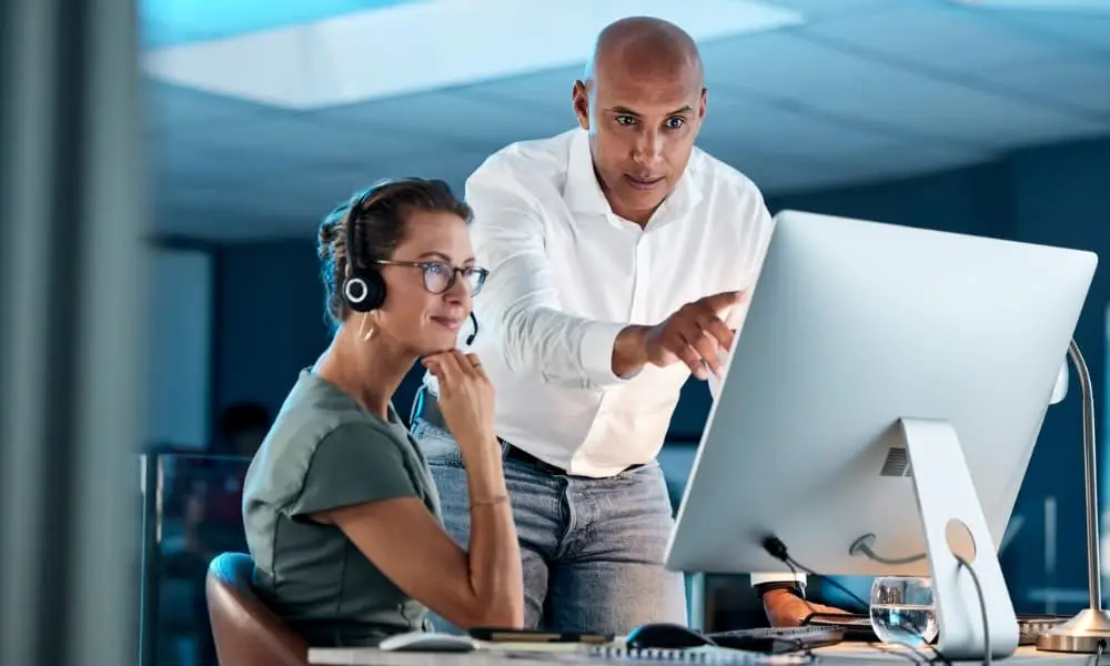Two Ops team members evaluating I.T. support Seattle WA options on desktop computer.