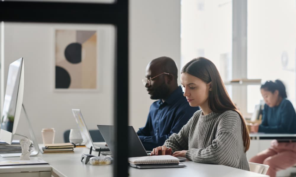 Employees working seamlessly through the benefits of managed I.T. services for small businesses.