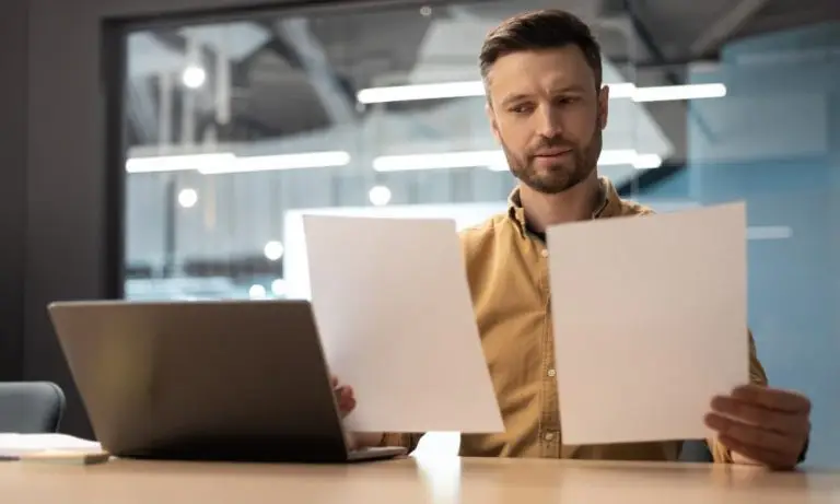 SMB owner comparing managed I.T. service pricing models on two papers